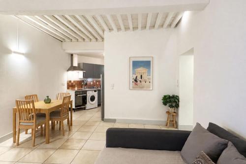 a living room with a couch and a table at Bright Nîmes Center Flat with Terrace in Nîmes