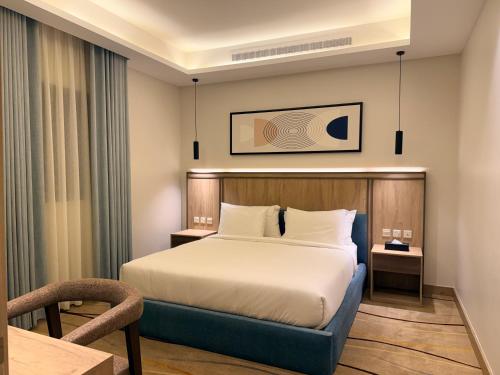 a hotel room with a bed and a chair at فندق أثير بارك in Jazan