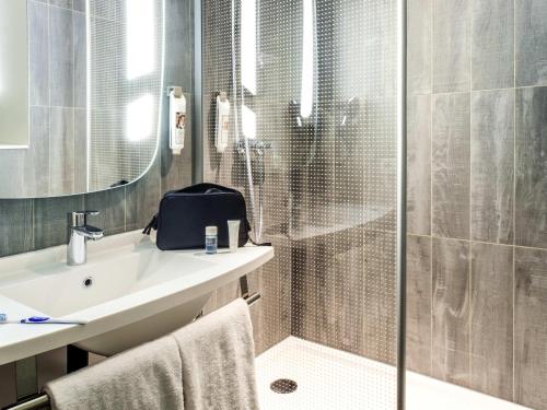 a bathroom with a shower and a sink and a toilet at Ibis Poznan Polnoc in Suchy Las