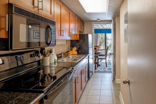 a kitchen with a sink and a stove top oven at Relaxing Oceanfront Condo - Holiday Pavilion 211 in Myrtle Beach
