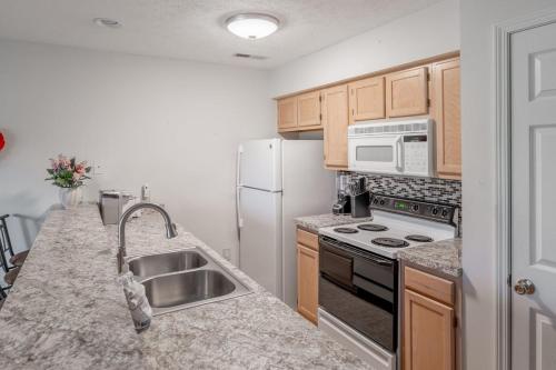 a kitchen with a sink and a white refrigerator at Charming Golf Getaway! River Oaks 19E in Myrtle Beach