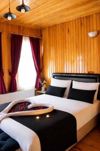 a bedroom with two beds with red curtains at Deal Otel in Uzungöl