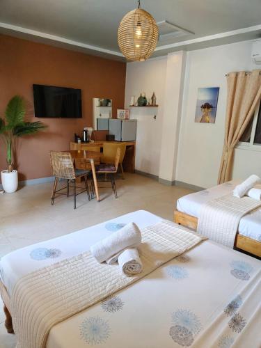 a hotel room with two beds and a dining room at Bellas Guest House in Pooc