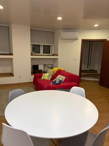 a living room with a white table and a red couch at Kasa102 in Gouveia