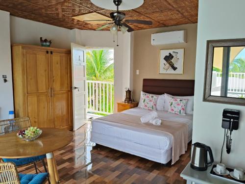 a bedroom with a bed and a table and a patio at Bellas Guest House in Pooc