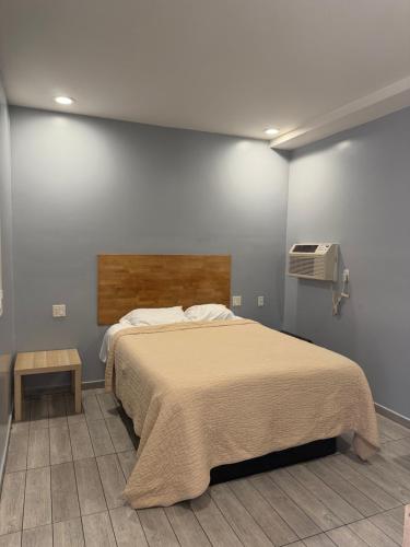 a bedroom with a large bed and a tv at Casa Motel in Los Angeles