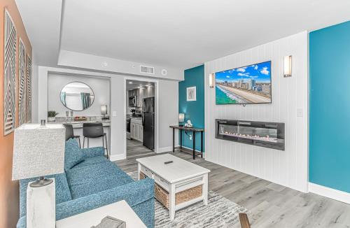 a living room with a blue couch and a table at Pristine Oceanfront Oasis With Breathtaking Views- Camelot 1614 in Myrtle Beach