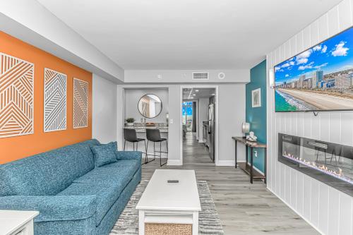 a living room with a blue couch at Pristine Oceanfront Oasis With Breathtaking Views- Camelot 1614 in Myrtle Beach