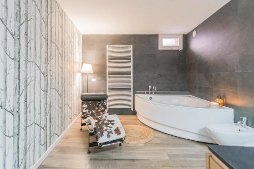 a bathroom with a tub and a chair in it at Villa Casa Pini by Rent All Como in Bellagio