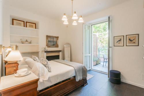 a bedroom with a bed and a door to a patio at Villa Casa Pini by Rent All Como in Bellagio