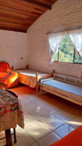 a bedroom with two beds and a window at Chácara chalé in Juquitiba
