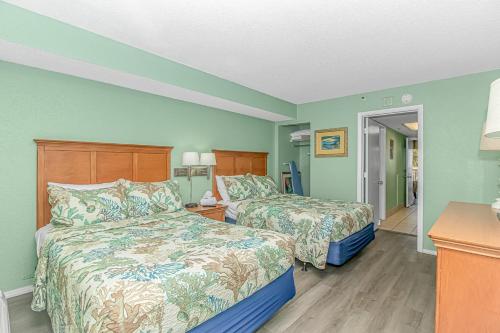 a hotel room with two beds and a hallway at Updated 2nd Floor 1BR for 4! Sailfish 210 in Myrtle Beach