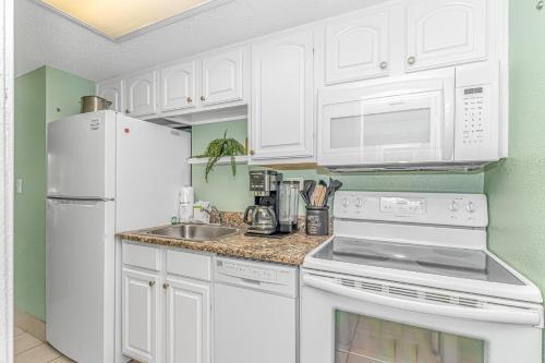 a white kitchen with white appliances and a sink at Updated 2nd Floor 1BR for 4! Sailfish 210 in Myrtle Beach