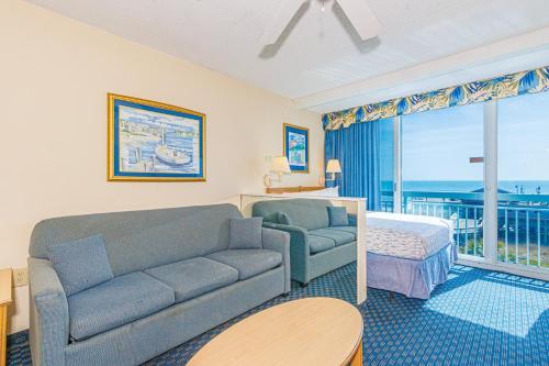 a living room with a couch and a bed at Oceanfront Suite -Steps to SkyWheel! Yachtsman 402 in Myrtle Beach