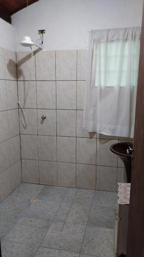 a bathroom with a shower with a shower curtain at Chácara chalé in Juquitiba