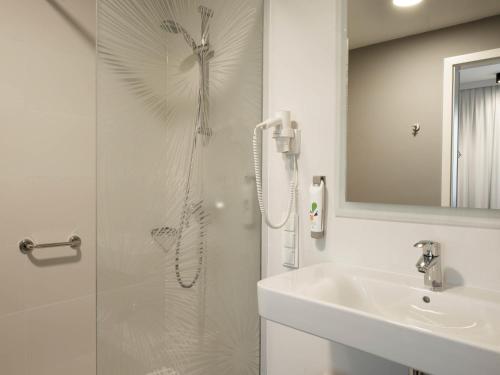 a white bathroom with a shower and a sink at ibis Styles Siedlce in Siedlce