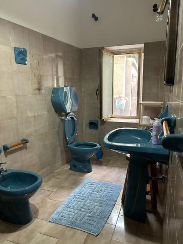 a bathroom with two sinks and a toilet and a window at Sa Mùrtya casa vacanza in Viddalba