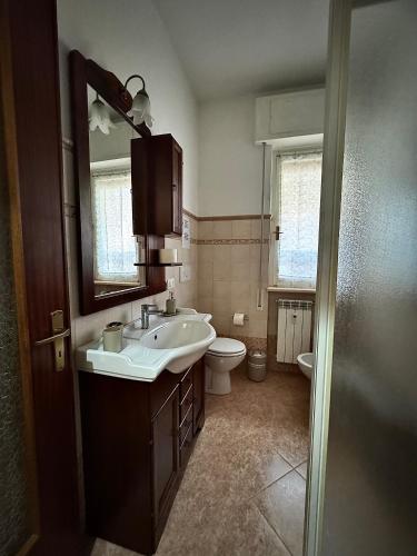 ein Badezimmer mit Waschbecken, Toilette und Spiegel in der Unterkunft 3WHome in Rapallo