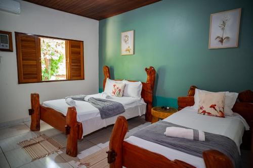 a room with two beds and a window at Pousada Aconchego in Pirenópolis