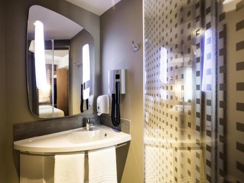 a bathroom with a sink and a mirror at ibis Yerevan Center in Yerevan