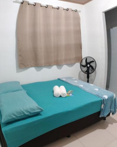 a bed with two white balls on top of it at Quarto 8km Aeroporto MCZ in Maceió