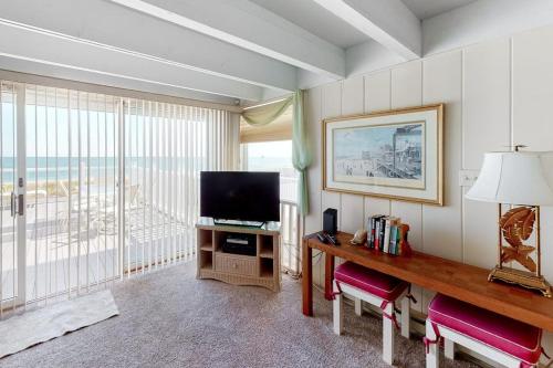a room with a television and a table with chairs at White Sands Village 30 in Ocean City