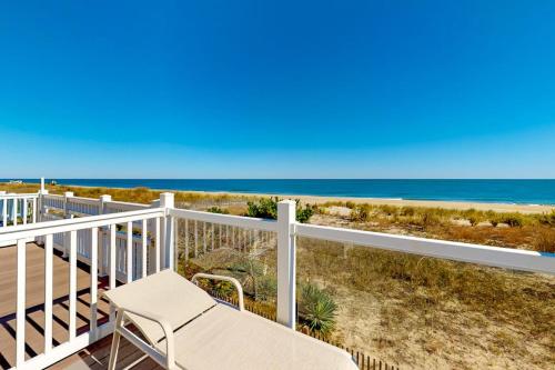 a white chair sitting on a balcony overlooking the beach at White Sands Village 30 in Ocean City