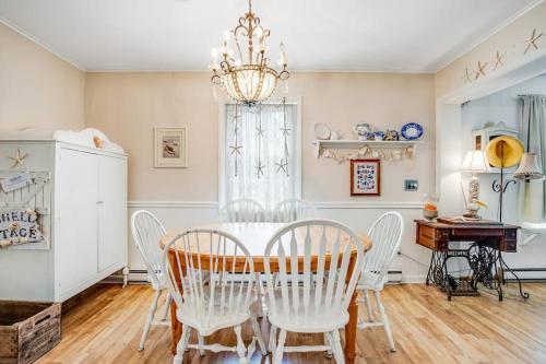 a dining room with a table and chairs and a chandelier at The Seashell Cottage in Ocean City