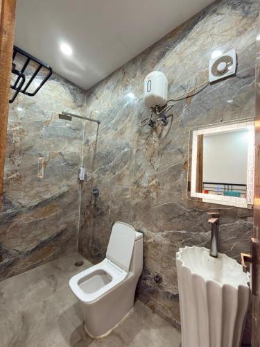 a bathroom with a toilet and a sink and a mirror at Luxurious Farm in Greater Noida