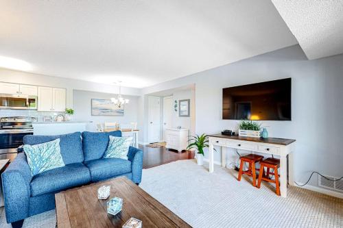a living room with a blue couch and a kitchen at Heron Haven in Ocean City