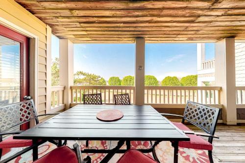 a porch with a table and chairs on a balcony at Heron Haven in Ocean City