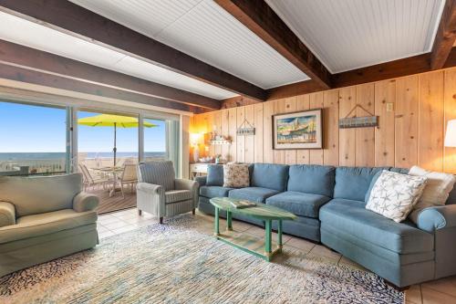 a living room with a blue couch and a table at Beach Village 6 in Ocean City