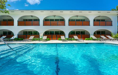 a swimming pool in front of a building at Casa Luz - Sunlit Boca Pool Retreat in Boca Raton