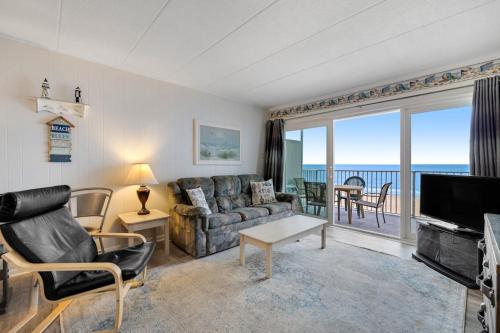 a living room with a couch and a television and a table at El Capitan 403 in Ocean City