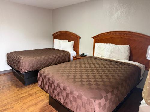 a hotel room with two beds in a room at Regency Inn in Muskogee
