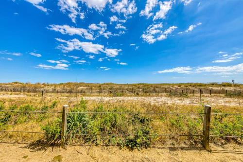 a fence in a field with a blue sky at Constellation House 107 in Ocean City