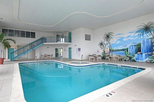 a large swimming pool in a building with a mural at Avalon 406 in Ocean City
