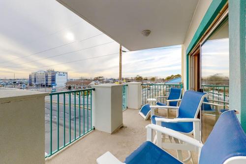 a balcony with blue chairs and a view of a harbor at Avalon 406 in Ocean City