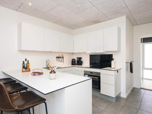 a kitchen with white cabinets and a counter top at 5 star holiday home in Ringkøbing in Ringkøbing