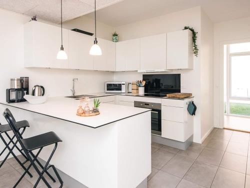 a white kitchen with white cabinets and appliances at 5 star holiday home in Ringkøbing in Ringkøbing