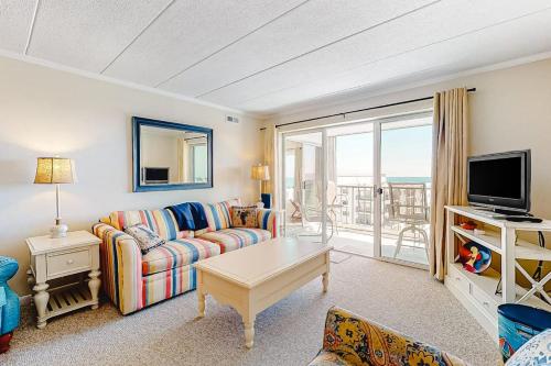 a living room with a couch and a tv at Excalibur 905 in Ocean City