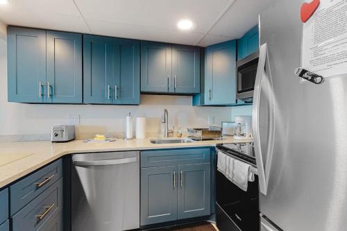 a kitchen with blue cabinets and a refrigerator at Excalibur 905 in Ocean City