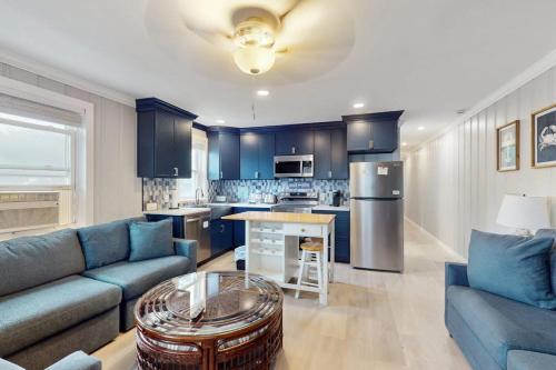 a living room with a blue couch and a kitchen at Straney #3-Sea Renity in Ocean City