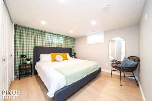 a bedroom with a bed with a mirror and a chair at Modern Urban Escape -King Bed -Pet Friendly - Free Parking & Netflix - Fast Wi-Fi in Edmonton