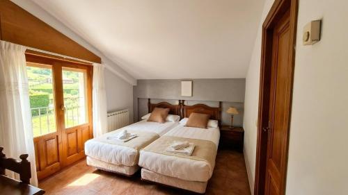 a bedroom with a large bed and a window at Hostal Bil in Salduero