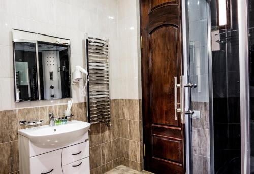 a bathroom with a sink and a mirror and a shower at S&L Boutique Hotel in Tbilisi City