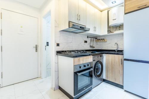 a kitchen with a stove and a washer and dryer at Appart-Hôtel Luxury SuiteMar in M'diq