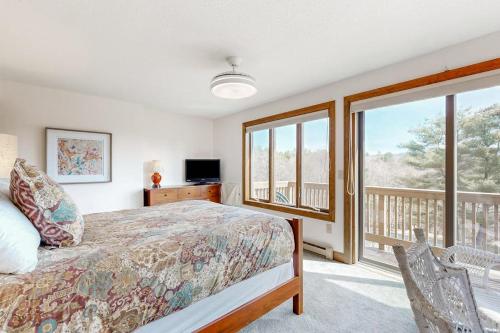 a bedroom with a bed and a balcony at Saltbox 12B in White River Junction
