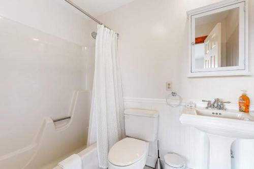 a white bathroom with a toilet and a sink at Saltbox 12B in White River Junction