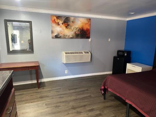 a room with a bedroom with a bed and a air conditioner at Driftwood Motel in Colton